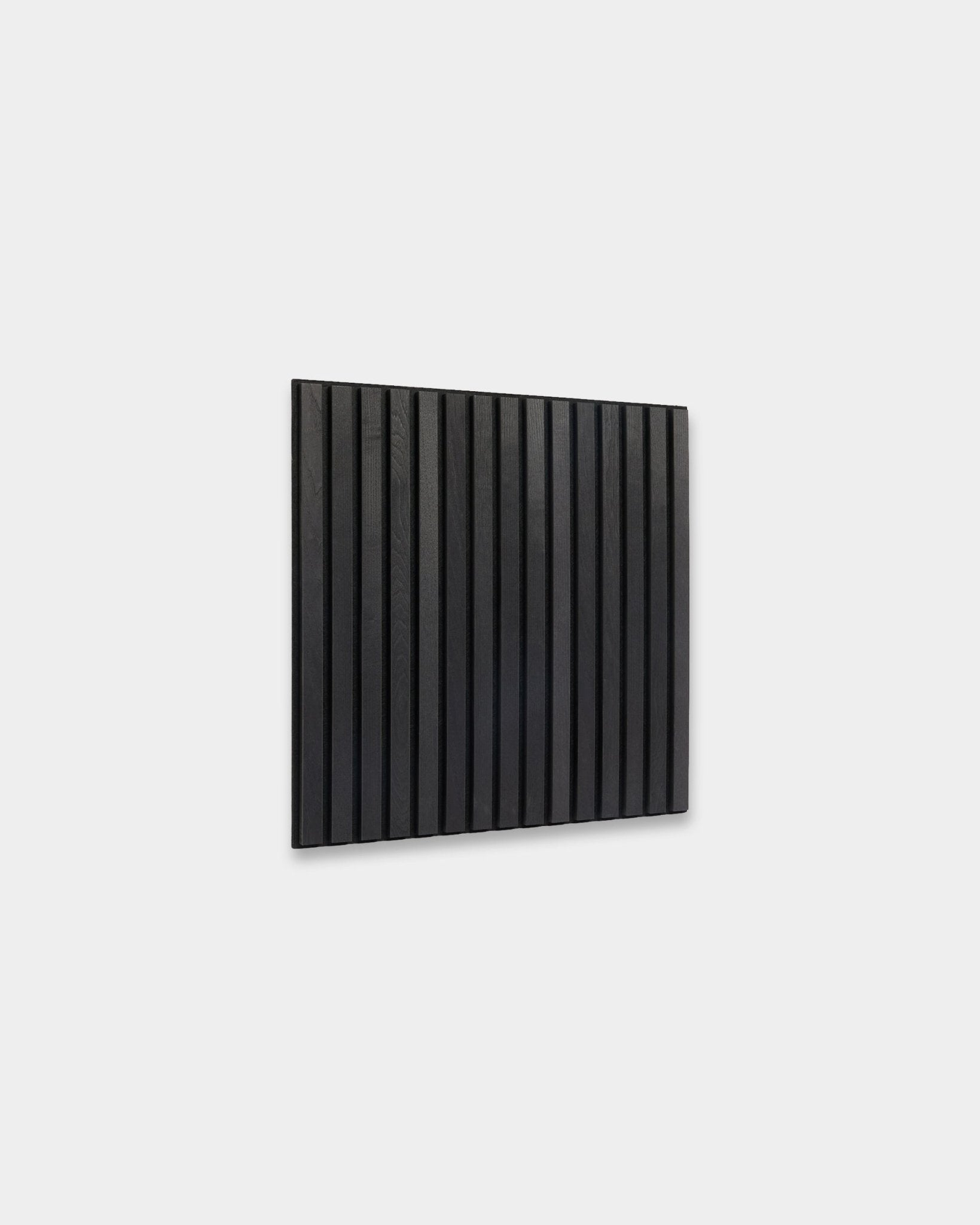 Panneau Akupixel Black Ash Panneau acoustique WoodUpp (60 x 60 cm) avec des lattes de bois verticales montées sur un mur gris clair, illustrant un design scandinave minimaliste.